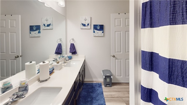 bathroom with wood-type flooring, vanity, and a shower with curtain