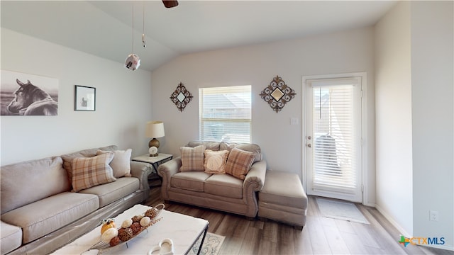 living room featuring hardwood / wood-style flooring, vaulted ceiling, and ceiling fan