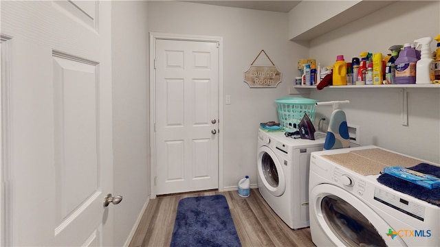 clothes washing area featuring washing machine and clothes dryer and light hardwood / wood-style flooring