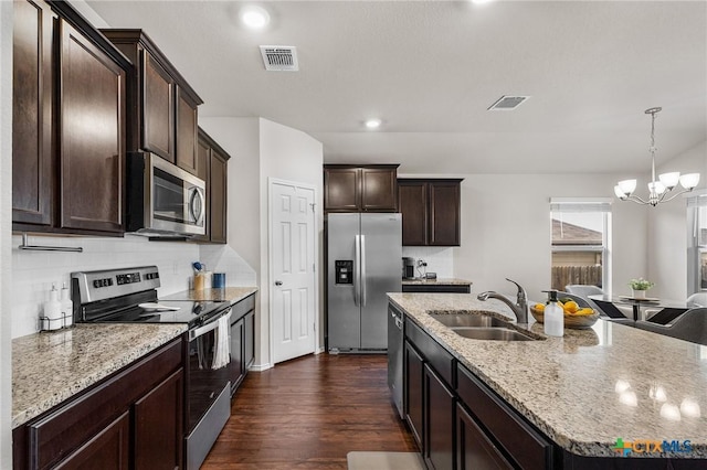 2020 Mallard Ct, Copperas Cove, TX 76522 - kitchen featuring appliances with stainless steel finishes, dark brown cabinetry, a chandelier, dark wood-style floors, and tasteful backsplash