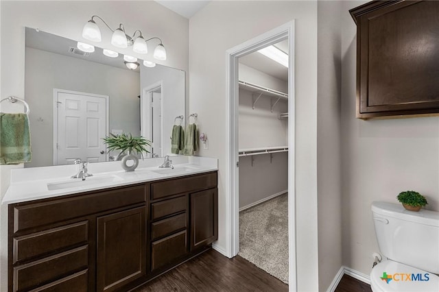 2020 Mallard Ct, Copperas Cove, TX 76522 - bathroom featuring wood finished floors, double vanity, and a spacious closet