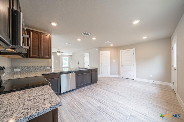 kitchen featuring visible vents, a sink, a peninsula, appliances with stainless steel finishes, and ceiling fan