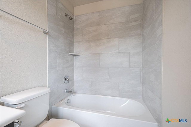 full bath featuring toilet, a textured wall, and bathtub / shower combination