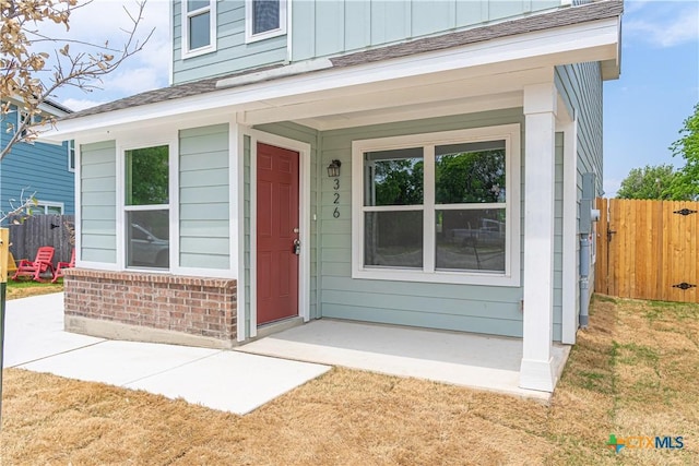 entrance to property featuring fence and board and batten siding