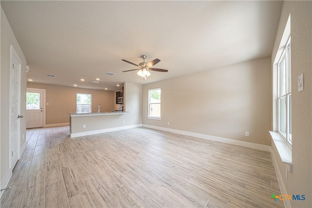unfurnished living room with a wealth of natural light, recessed lighting, light wood-style floors, and ceiling fan