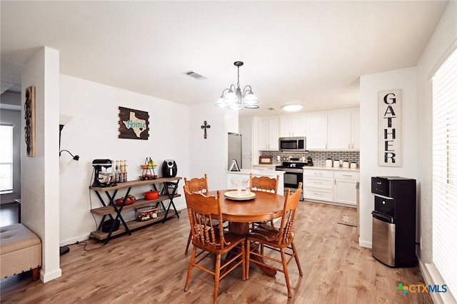 dining room with a notable chandelier and light hardwood / wood-style floors