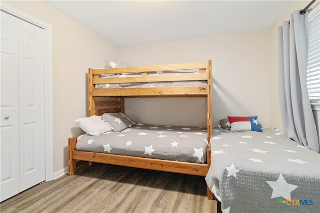 bedroom featuring hardwood / wood-style floors and a closet