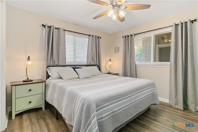 bedroom featuring hardwood / wood-style flooring, ceiling fan, and multiple windows