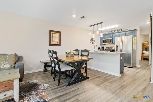 dining space featuring sink and light hardwood / wood-style flooring