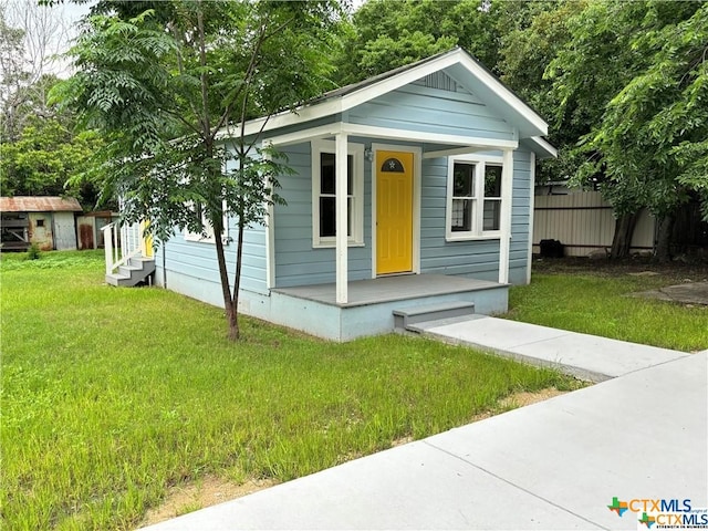 view of outbuilding with a lawn and a porch