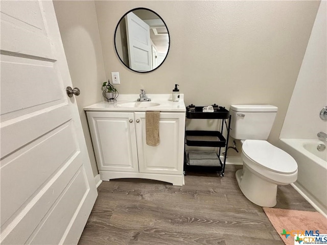 full bathroom featuring hardwood / wood-style flooring, vanity, toilet, and shower / washtub combination