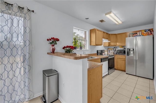 kitchen with kitchen peninsula, sink, light tile patterned floors, and stainless steel appliances