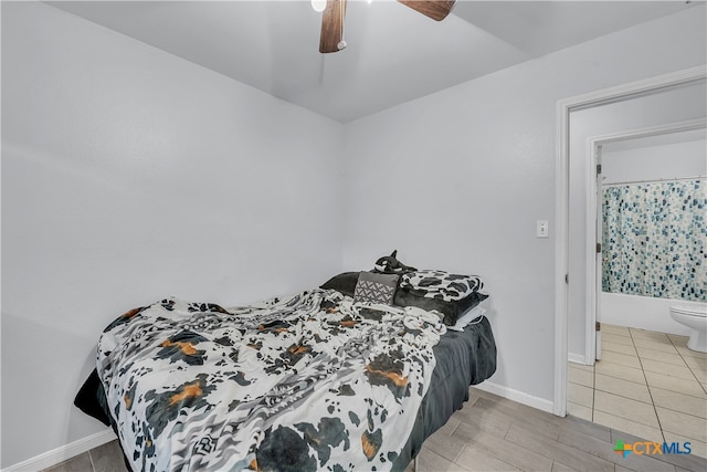 bedroom featuring connected bathroom, light tile patterned flooring, and ceiling fan