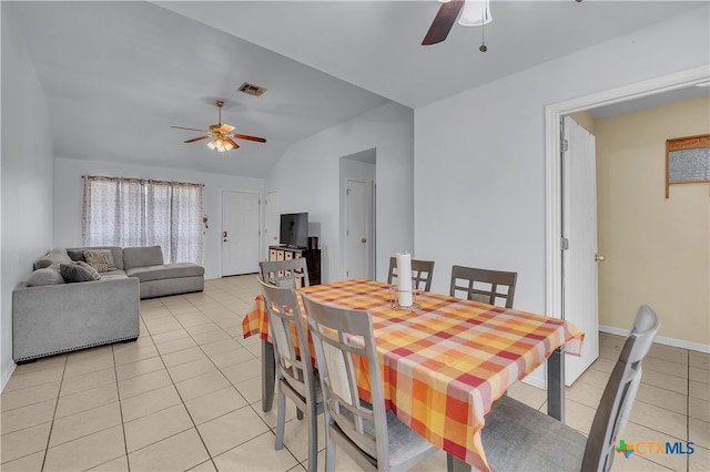 dining area with light tile patterned flooring, ceiling fan, and vaulted ceiling