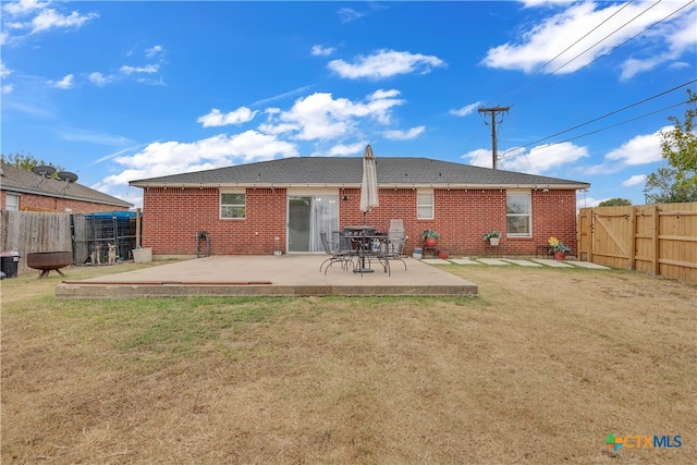 back of property with a lawn and a patio area