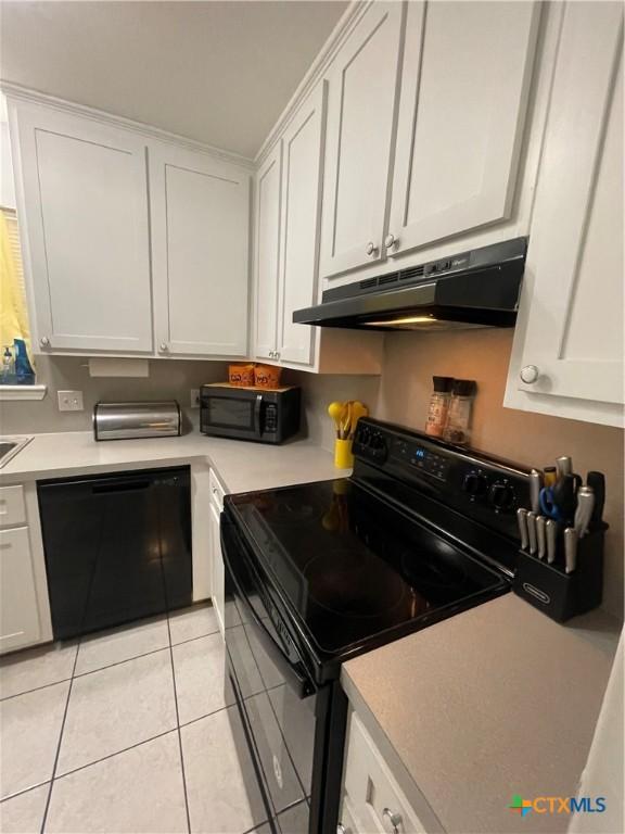 110 Idylwood Pl, Victoria, TX 77901 - kitchen featuring black appliances, under cabinet range hood, white cabinetry, light tile patterned floors, and light countertops