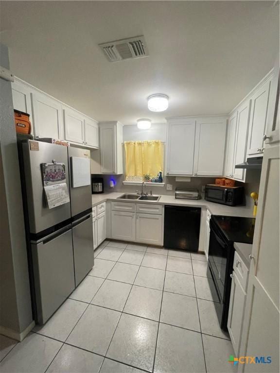 110 Idylwood Pl, Victoria, TX 77901 - kitchen with black appliances, a sink, light tile patterned floors, white cabinetry, and under cabinet range hood