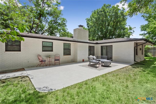 2302 Brooklawn Dr, Temple, TX 76502 - back of property with brick siding, a chimney, a patio, and a lawn