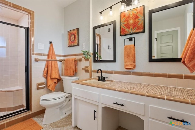 2302 Brooklawn Dr, Temple, TX 76502 - bathroom featuring tile walls, a stall shower, vanity, tile patterned flooring, and a wainscoted wall