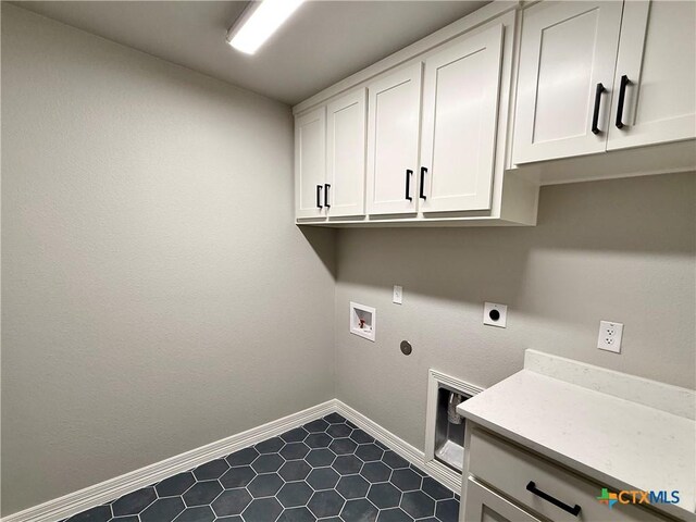 laundry area with baseboards, cabinet space, electric dryer hookup, washer hookup, and dark tile patterned flooring