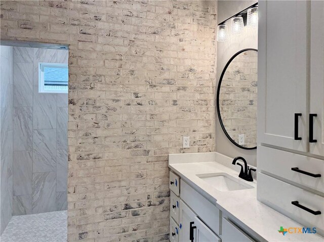 bathroom with vanity and brick wall