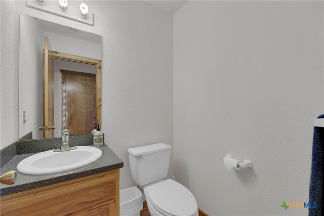 bathroom featuring toilet and vanity