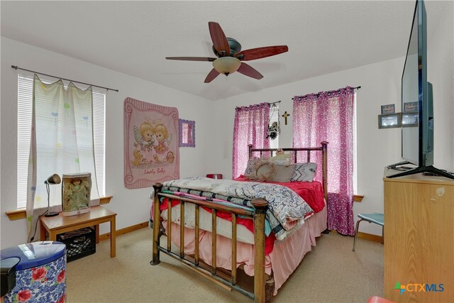 carpeted bedroom with multiple windows and ceiling fan