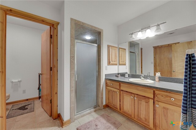 bathroom with walk in shower, tile patterned flooring, vanity, and toilet