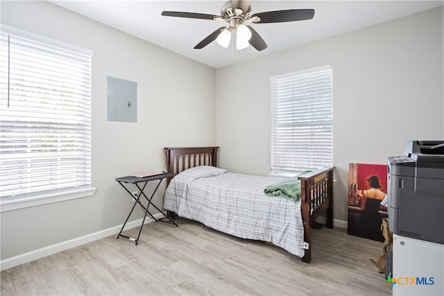 bedroom with electric panel, light hardwood / wood-style floors, and ceiling fan