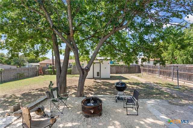 view of yard with a storage unit, a patio, and a fire pit