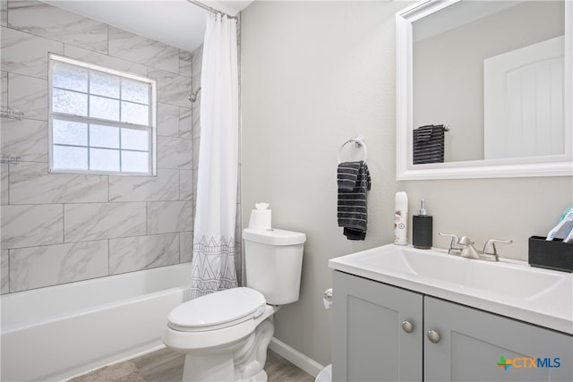 full bathroom with wood-type flooring, shower / bath combination with curtain, toilet, and vanity