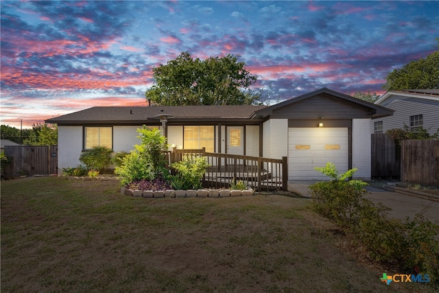 ranch-style home with a garage and a lawn