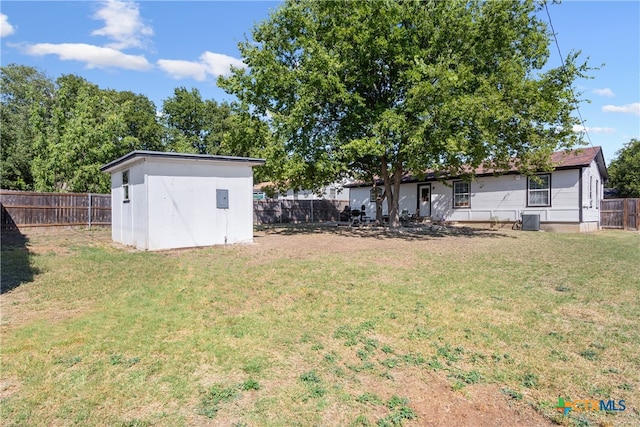 view of yard featuring central air condition unit and a storage unit