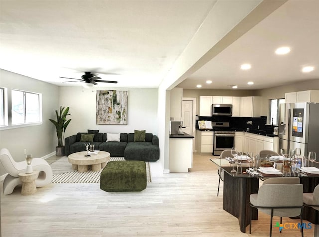 living room with ceiling fan and light hardwood / wood-style flooring