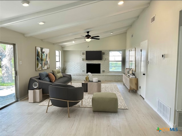 living room featuring lofted ceiling with beams, light hardwood / wood-style floors, and a wealth of natural light