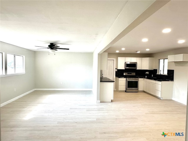 kitchen featuring white cabinetry, ceiling fan, stainless steel appliances, tasteful backsplash, and light hardwood / wood-style floors