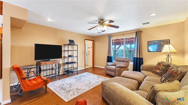 living room with dark wood-type flooring and ceiling fan