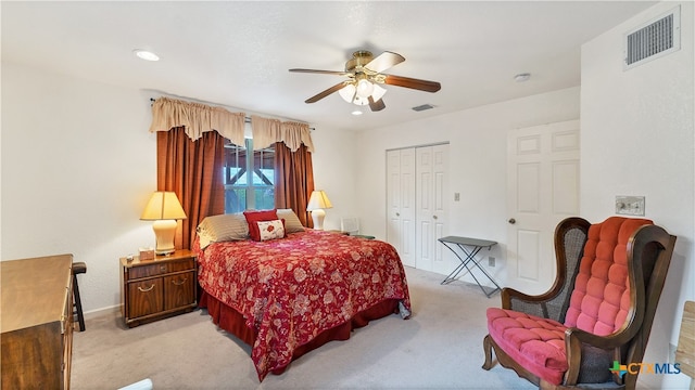 bedroom with light carpet, ceiling fan, and a closet