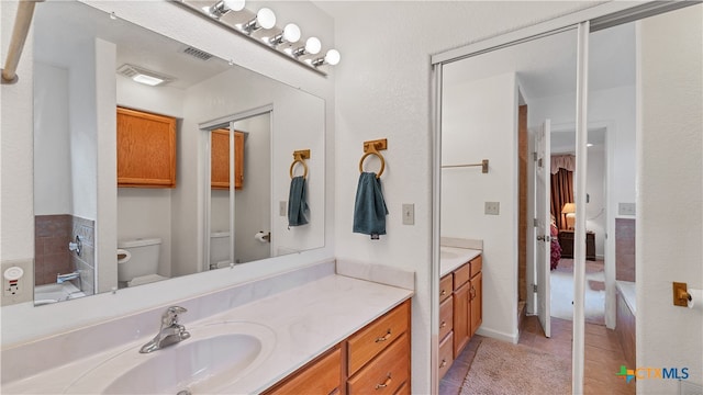 bathroom featuring toilet, vanity, and tile patterned flooring