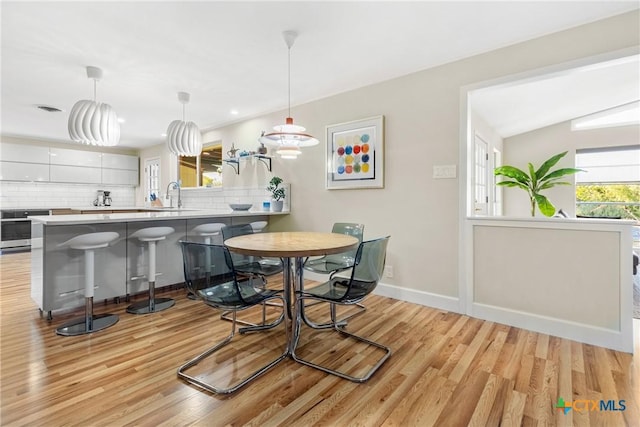 dining area featuring sink and light hardwood / wood-style flooring