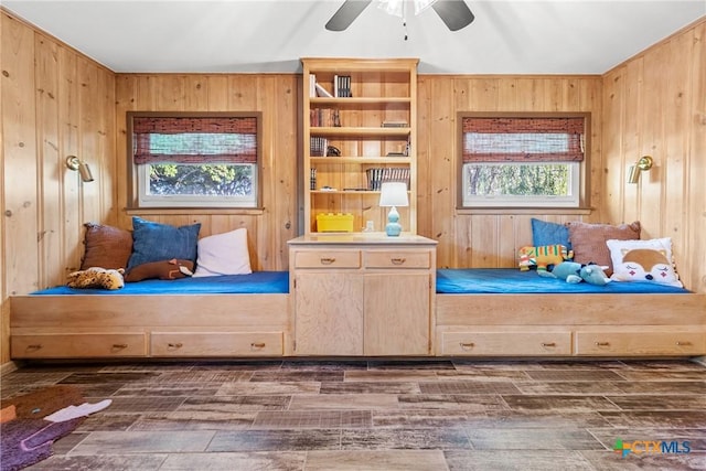 living area featuring dark wood-type flooring, plenty of natural light, and wooden walls