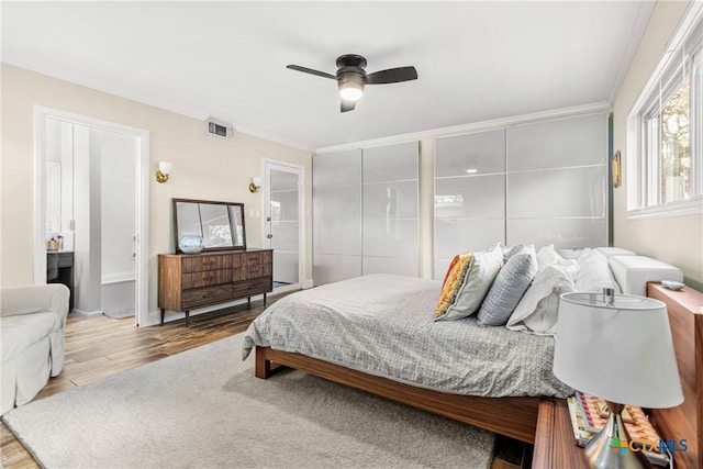 bedroom featuring wood-type flooring, ornamental molding, and ceiling fan