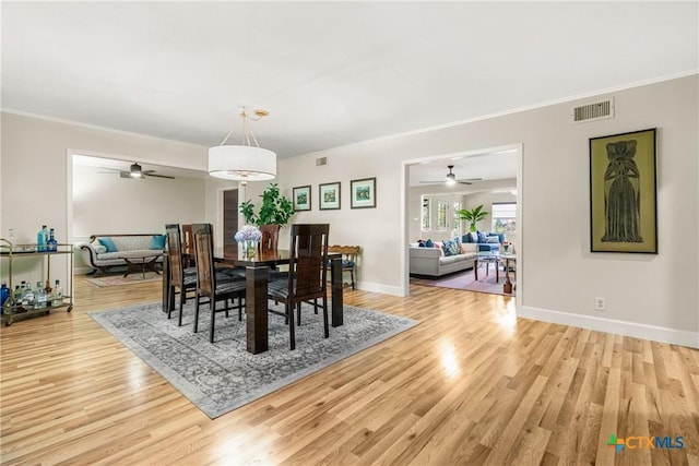 dining space featuring crown molding, light hardwood / wood-style floors, and ceiling fan