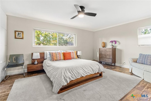 bedroom with hardwood / wood-style flooring, crown molding, and multiple windows