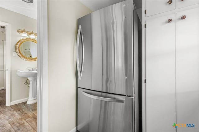 kitchen featuring white cabinetry, stainless steel fridge, and light hardwood / wood-style flooring