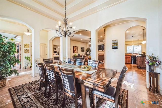 dining area featuring ornamental molding, light tile patterned flooring, and a high ceiling