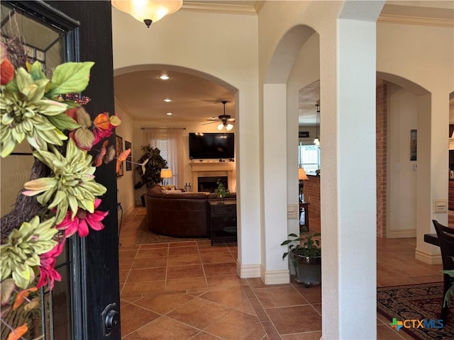 hallway featuring ornamental molding and dark tile patterned flooring