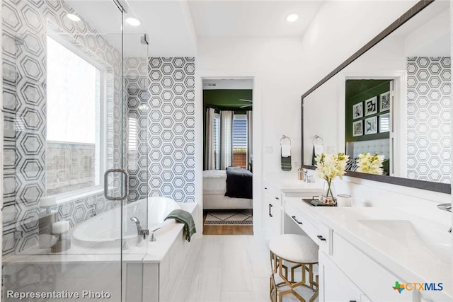 bathroom with vanity, a tub to relax in, and a healthy amount of sunlight