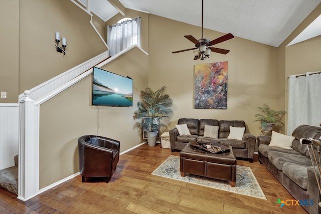 living room with high vaulted ceiling, beamed ceiling, hardwood / wood-style flooring, and ceiling fan