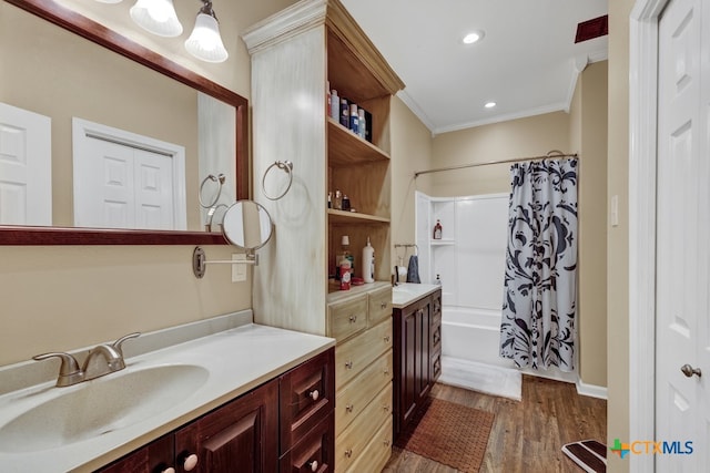 bathroom featuring hardwood / wood-style flooring, vanity, shower / bath combo with shower curtain, and crown molding